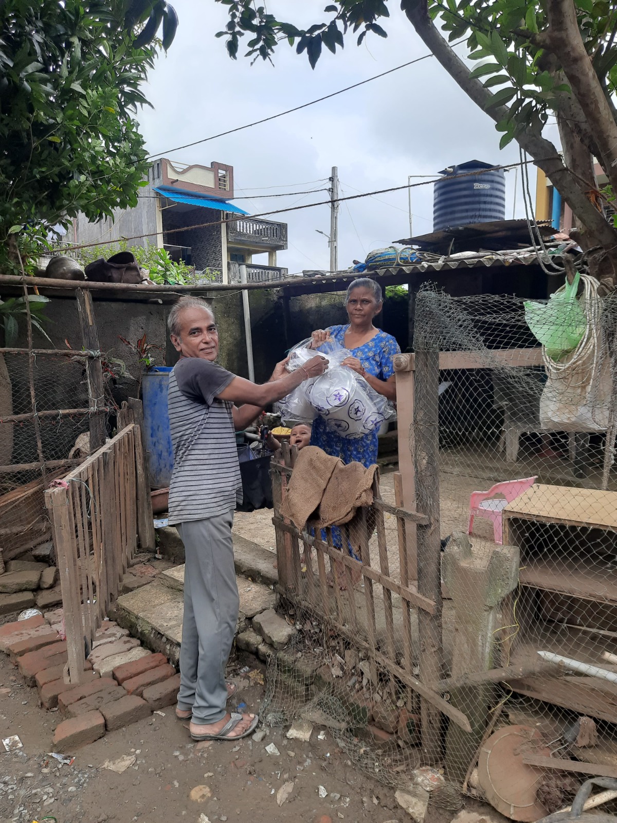 A beneficiary family receiving kitchen containers